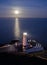 Lighthouse with Full Moon Reflecting in Sea