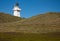 A lighthouse on a grassy hill at Waipapa Point in the Catlins in the South Island in New Zealand
