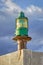 Lighthouse green beacon against blue sky