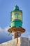 Lighthouse green beacon against blue sky