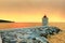 Lighthouse in the harbor of a small town Postira shot at sunset - Croatia, island Brac