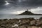 Lighthouse on headland with sun beams over ocean landscape with