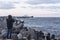 Lighthouse and high wave above it and cargo ship in windy winter in Baltic sea