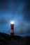 Lighthouse in HÃ¶rnum on Sylt Island Germany at night with drifting clouds