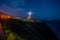 Lighthouse illuminating at cliff at night