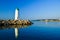 The lighthouse, located on the rocks of the breakwater, is reflected in the water