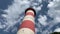 Lighthouse on a moving cloud background. Bottom view.