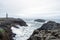 Lighthouse next to Nato base in Stokksnes peninsula next to the city of Hofn in Iceland. Waves crash ashore with overcast sky