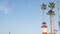 Lighthouse, palm trees and blue sky. Red and white beacon. Waterfront harbor village. California USA