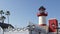 Lighthouse, palm trees and blue sky. Red and white beacon. Waterfront harbor village. California USA