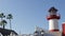 Lighthouse, palm trees and blue sky. Red and white beacon. Waterfront harbor village. California USA