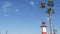 Lighthouse, palm trees and blue sky. Red and white beacon. Waterfront harbor village. California USA