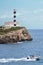 Lighthouse in Portocolom. Motorboat on the sea wit blue sky. Mallorca