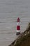 Lighthouse red and white striped on stormy winter day.