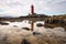 lighthouse reflected in tidal pools during low tide