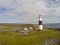 Lighthouse, rocky beach and farms  in Inisheer island