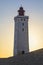 Lighthouse at Rubjerg Knude, Denmark against setting sun