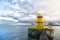 Lighthouse on sea pier in reykjavik iceland. Lighthouse yellow bright tower at sea shore. Sea port navigation concept