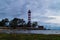 Lighthouse shines near the shore at sunset