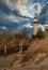 Lighthouse Shining its Light Along the Seashore under Cloudy Skies