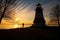 lighthouse silhouette casting long shadows at dawn