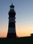 Lighthouse silhouette at sunset in Plymouth Ocean