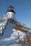 Lighthouse On Snow Covered Cliff