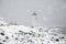 Lighthouse in Snowstorm by Rocky Coast in New England