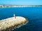 Lighthouse on the stone breakwater at harbor mouth aerial view