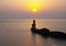 Lighthouse and sun at sunset at the exit of the port of Pasaia, Euskadi