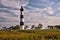 Lighthouse surrounded by clouds and marshland