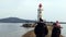 Lighthouse on Tokarev cat, people walk near the sights.