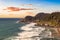 Lighthouse on top of the rocky shore of Pacific Ocean.