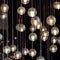 Lighting balls on the chandelier in the lamplight, light bulbs hanging from the ceiling, lamps on the dark background, selective