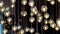 Lighting balls on the chandelier in the lamplight, light bulbs hanging from the ceiling, lamps on the dark background, selective