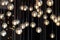 Lighting balls on the chandelier in the lamplight, light bulbs hanging from the ceiling, lamps on the dark background, selective