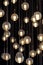 Lighting balls on the chandelier in the lamplight, light bulbs hanging from the ceiling, lamps on the dark background, selective