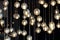 lighting balls on the chandelier in the lamplight, light bulbs hanging from the ceiling, lamps on the dark background, selective