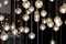 Lighting balls on the chandelier in the lamplight, light bulbs hanging from the ceiling, lamps on the dark background, selective