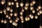 lighting balls on the chandelier in the lamplight, light bulbs hanging from the ceiling, lamps on the dark background, selective