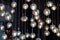 Lighting balls on the chandelier in the lamplight, light bulbs hanging from the ceiling, lamps on the dark background, selective