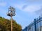 Lighting mast with powerful spotlights over the stadium against the blue sky copy space