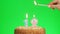Lighting a number twelve birthday candle on a delicious cake, green screen 12