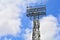 Lighting support. Stadium Post Lighting. Tall pillar with spotlights to illuminate a football stadium against the sky with clouds