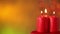 Lighting three xmas candles against blurry christmas lights background