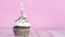 Lighting up birthday candle on chocolate cup cake with cream