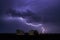 Lightning in big cloud over night city. Black stormy backdrop. Thunderstorm weather. Sky clouds. Dark dramatic scene