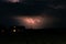 Lightning bolt over a house wriggles through the sky