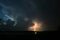 Lightning bolt strikes down to earth from the cloud of a thunderstorm at dusk