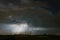 A lightning bolt strikes down to earth from a large storm cloud Cumulonimbus.